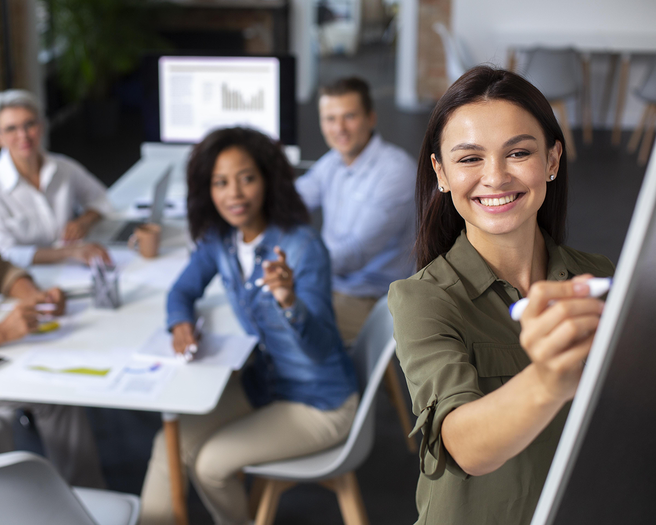 Mujer dando capacitación a grupo de personas que buscan empleo